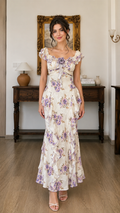 Front view of ivory floral off-shoulder maxi dress with ruffle sleeves and rosette detail